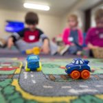 a group of children playing with toys on the floor